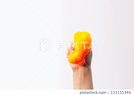 Hand squeeze orange stress ball on white background. Positive thinking concept. Copy space 131155344