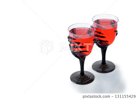 Halloween spooky red cocktail in skeleton hand glass 131155429