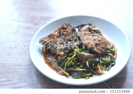 spicy deep fried chop Nile Tilapia or mango fish slice ginger and ear mushroom couple celery dressing soy sauce on plate  131155494