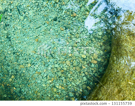 Crystal clear water reveals smooth stones and pebbles in a serene natural setting, captured during bright daylight in a tranquil forest stream Crystal clear water reveals smooth stones and pebbles in a serene natural setting, captured during bright daylight in a tranquil forest stream 131155739