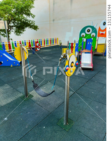 Colorful playground equipment featuring swings and slides in a sunny outdoor space, designed for children to play and explore creativity Colorful playground equipment featuring swings and slides in a sunny outdoor space, designed for children to play and explore creativity 131155744