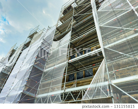 Restoration work transforms historic building as scaffolding envelops the structure under a cloudy sky Restoration work transforms historic building as scaffolding envelops the structure under a cloudy sky 131155815