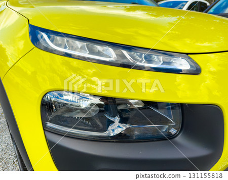 Bright yellow car close-up showcasing sleek headlights during a vibrant outdoor car show in summer Bright yellow car close-up showcasing sleek headlights during a vibrant outdoor car show in summer 131155818