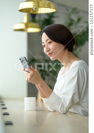 A woman using her smartphone in a cafe 131157177