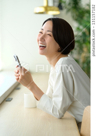A woman using her smartphone in a cafe A woman using her smartphone in a cafe 131157182