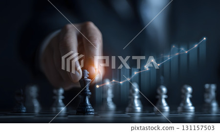 businessman placing chess piece on board with glowing chart overlay 131157503