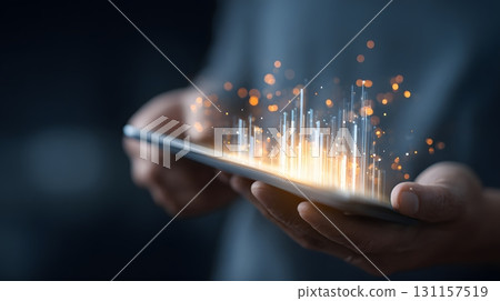hands holding transparent tablet with glowing investment data 131157519