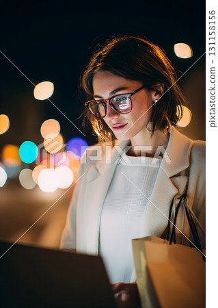 Young professional shopping online at night with soft laptop glow 131158156