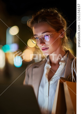 Young professional shopping online at night with soft laptop glow 131158157