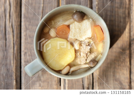 盛在湯杯裡的豬肉味噌湯,裡面有許多地瓜 盛在湯杯裡的豬肉味噌湯,裡面有許多地瓜 131158185
