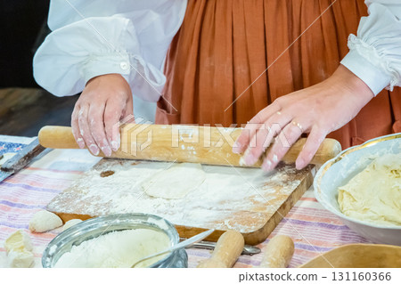 woman rolls out the dough for pies with a rolling pin close up woman rolls out the dough for pies with a rolling pin close up 131160366