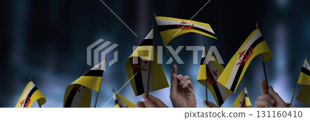 Brunei flags in their hands on a blurred urban background Brunei flags in their hands on a blurred urban background 131160410
