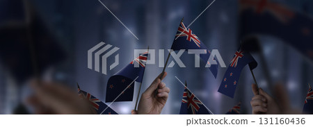 New Zealand flags in their hands on a blurred urban background New Zealand flags in their hands on a blurred urban background 131160436