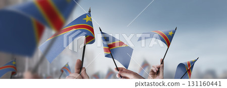 Democratic Republic of the Congo flags in their hands on a blurred urban background Democratic Republic of the Congo flags in their hands on a blurred urban background 131160441