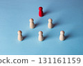 Red wooden figure leading team pyramid on blue background 131161159