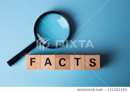 Magnifying glass examining facts word on wooden blocks 131161163