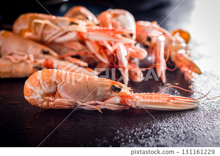 Scampi langoustine on black table. Scampi langoustine on black table. 131161229