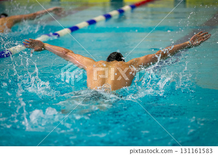 Two swimmers performing butterfly stroke at swimming competition 131161583