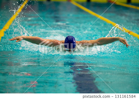 Athlete swimmer swimming in butterfly style pool Athlete swimmer swimming in butterfly style pool 131161584