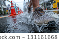 Boots stepping through puddles on the street during a rainy day in the city 131161668