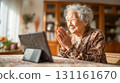 An elderly woman streaming on her smartphone in her living room at home 131161670