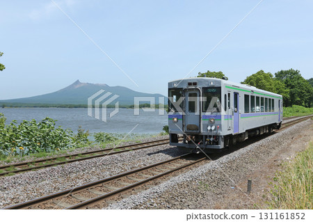 Hakodate Main Line local train Kiha 150 running along the shore of Lake Konuma with Mount Komagatake in the background Hakodate Main Line local train Kiha 150 running along the shore of Lake Konuma with Mount Komagatake in the background 131161852
