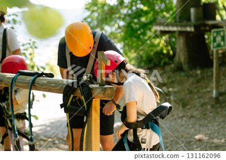 Child getting safety instructions in climbing park with instructor. outdoor activity Child getting safety instructions in climbing park with instructor. outdoor activity 131162096