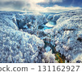 Aerial view of waterfalls and turquoise lakes in snowy forest 131162927