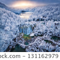 Aerial drone view of frozen waterfall, lakes in snowy forest 131162979