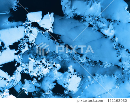 Aerial drone view of cracked ice floes on frozen lake surface 131162980