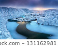 Aerial view of frozen lakes, waterfalls and snowy forest. Winter 131162981