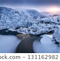 Aerial view of frozen lakes, waterfalls and snowy forest. Winter 131162982