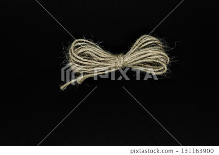 Ribbon from brown rope isolated on black background surface Ribbon from brown rope isolated on black background surface 131163900