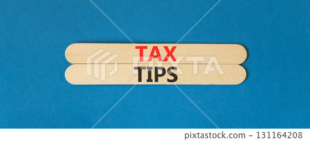 Tax tips symbol. Concept word Tax tips on beautiful wooden sticks. Beautiful blue paper background. Business tax tips concept. Copy space. Tax tips symbol. Concept word Tax tips on beautiful wooden sticks. Beautiful blue paper background. Business tax tips concept. Copy space. 131164208