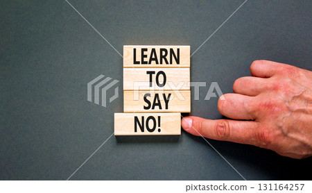 Learn to say no symbol. Concept words phrase Learn to say no on beautiful wooden blocks. Beautiful grey paper background. Businessman's hand. Business psychological Learn to say no concept. Copy space 131164257