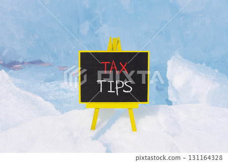 Tax tips symbol. Concept word Tax tips on beautiful black blackboard. Beautiful Baikal blue ice and snow background. Black blackboard. Business tax tips concept. Copy space. Tax tips symbol. Concept word Tax tips on beautiful black blackboard. Beautiful Baikal blue ice and snow background. Black blackboard. Business tax tips concept. Copy space. 131164328