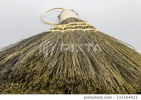 Straw broom on grey background Straw broom on grey background 131164421