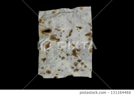 Very old and aged white paper sheet with brown spots on it isolated on black background surface Very old and aged white paper sheet with brown spots on it isolated on black background surface 131164468