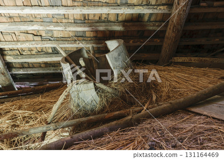 Very old and broken wooden tub lying in the barn attic on hay straw 131164469