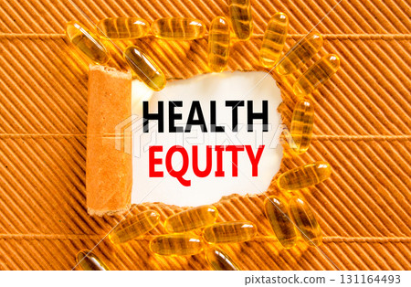 Health equity symbol. Concept words Health equity on beautiful white paper. Yellow pills tablets. Beautiful brown background. Medical healthy lifestyle health equity concept. Health equity symbol. Concept words Health equity on beautiful white paper. Yellow pills tablets. Beautiful brown background. Medical healthy lifestyle health equity concept. 131164493