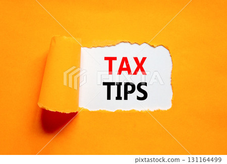 Tax tips symbol. Concept word Tax tips on beautiful white paper. Beautiful orange paper background. Business tax tips concept. Copy space. 131164499