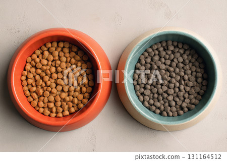 Two bowls filled with dry pet food, top view 131164512