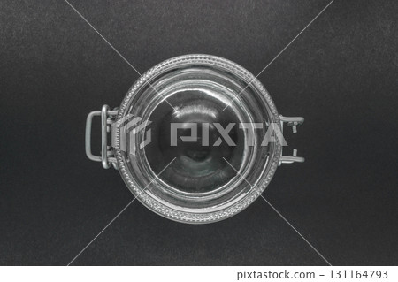 View from top of closed glass jar with metal holder on black background surface 131164793