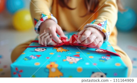Child's Hands Unwrapping a Colorful Birthday Gift with Confetti Background 131164909