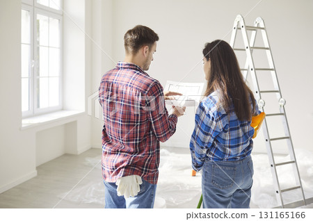 Married Couple Planning Renovation With Blueprint At Home 131165166