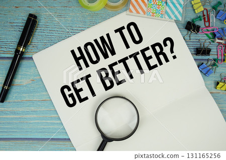 How To Get Better? text on a paper surrounded by office supplies and magnifying glass on a blue wooden surface 131165256