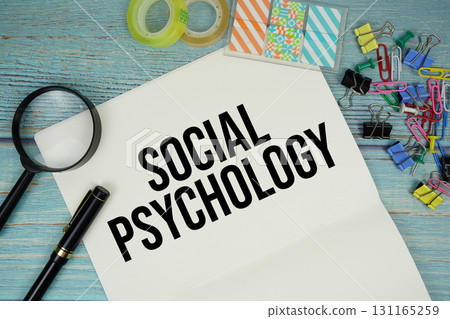 Social Psychology text on a paper surrounded by office supplies and magnifying glass on a blue wooden surface Social Psychology text on a paper surrounded by office supplies and magnifying glass on a blue wooden surface 131165259
