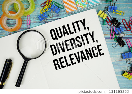 Quality, Diversity, Relevance text on a paper surrounded by office supplies and magnifying glass on a blue wooden surface 131165263