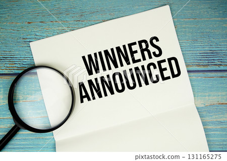 Winners Announced text written on notepad with magnifying glass flat lay on wooden background Winners Announced text written on notepad with magnifying glass flat lay on wooden background 131165275