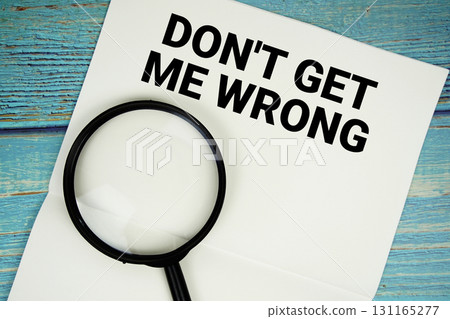 Don't Get Me Wrong text written on notepad with magnifying glass flat lay on wooden background 131165277